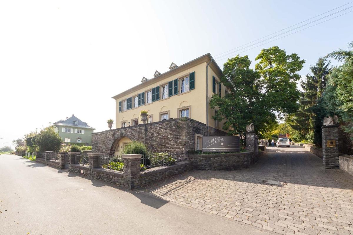 ein Gebäude an einer Straße mit einer Backsteinmauer in der Unterkunft Wein- und Landhaus S A Prüm in Bernkastel-Kues