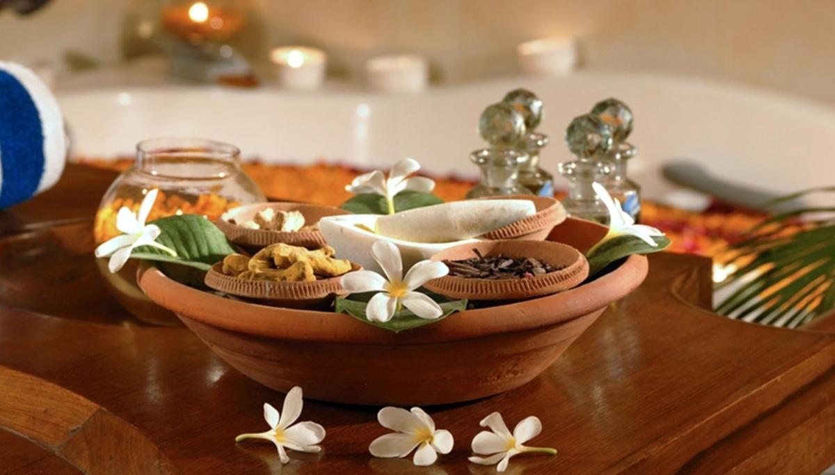 a bowl of food on a wooden table with flowers at The Grand Imperial - Heritage Hotel in Agra