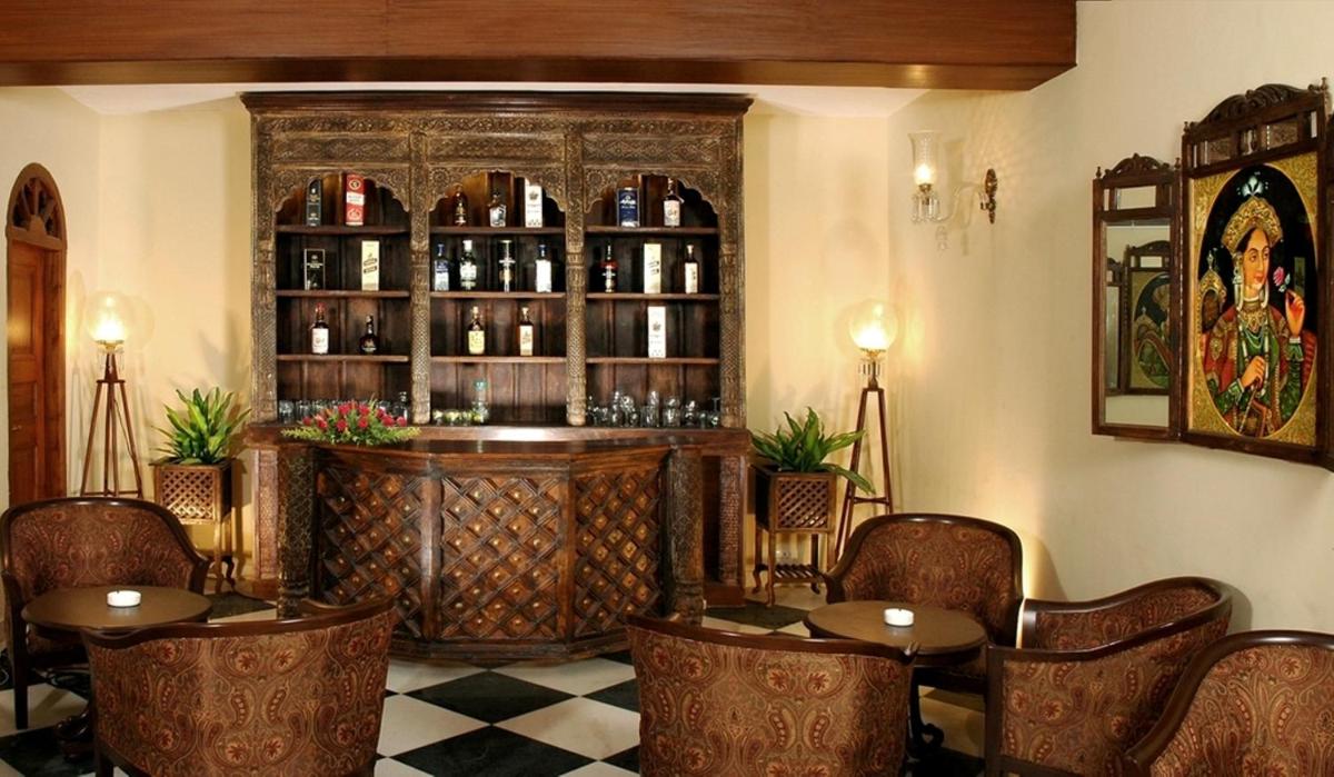 a restaurant with tables and a bar with wine bottles at The Grand Imperial - Heritage Hotel in Agra