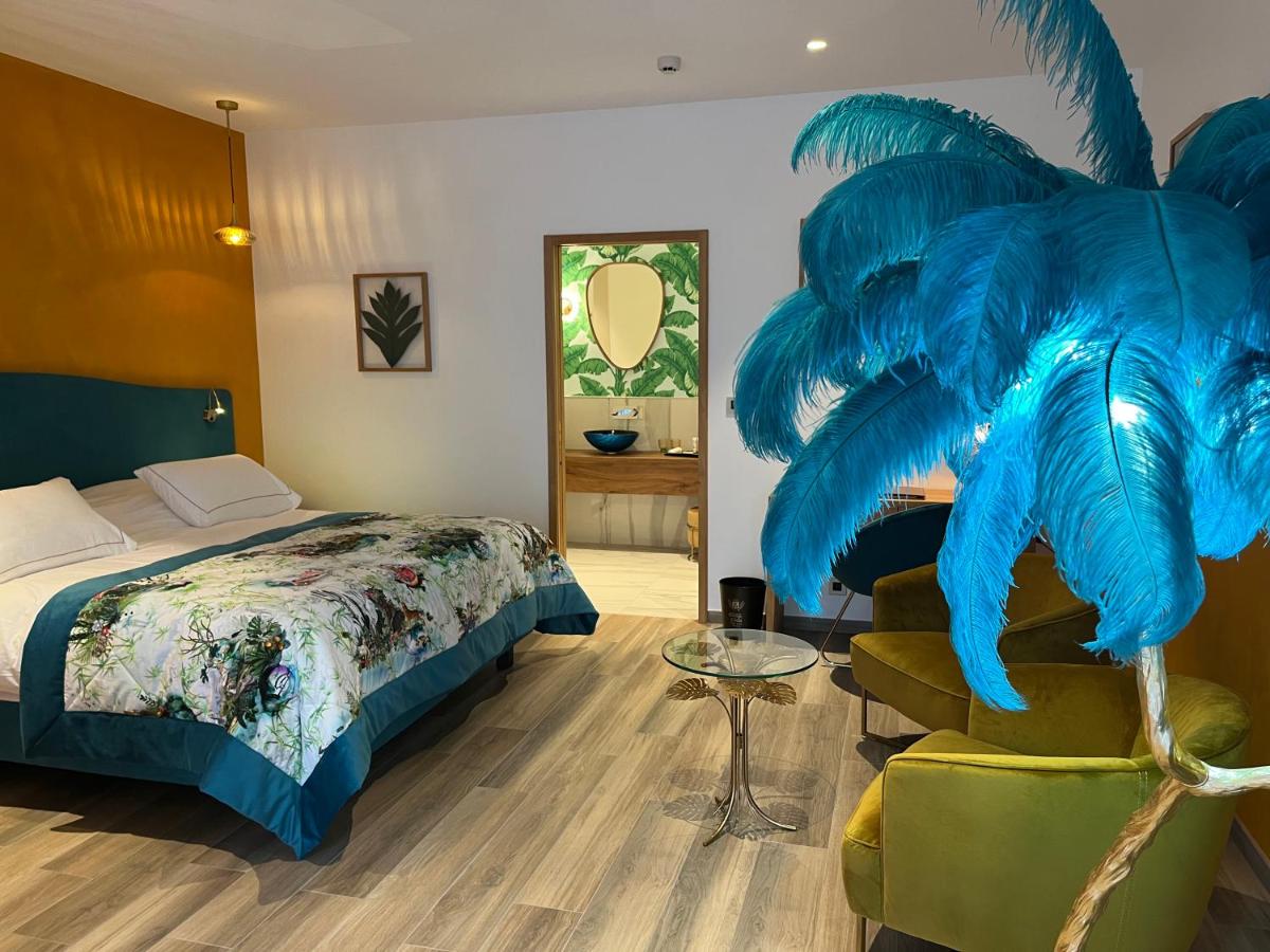 une chambre d'hôtel avec un lit et une plume bleue dans l'établissement Hôtel du Domaine de La Grange de Condé, à Condé-Northen