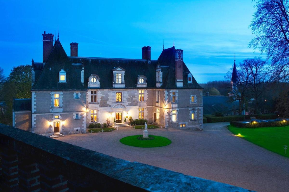 une vieille maison éclairée dans la cour dans l'établissement Château de Noizay - ChâteauZen, à Noizay