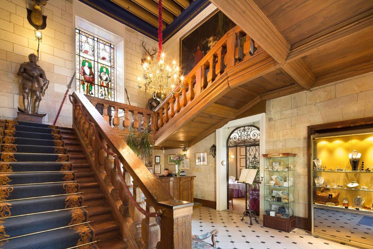 un escalier dans un bâtiment avec une statue sur le mur dans l'établissement Château de Noizay - ChâteauZen, à Noizay
