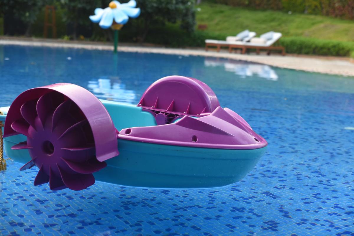 a pink and purple toy boat in a swimming pool at Taj Aravali Resort & Spa Udaipur in Udaipur