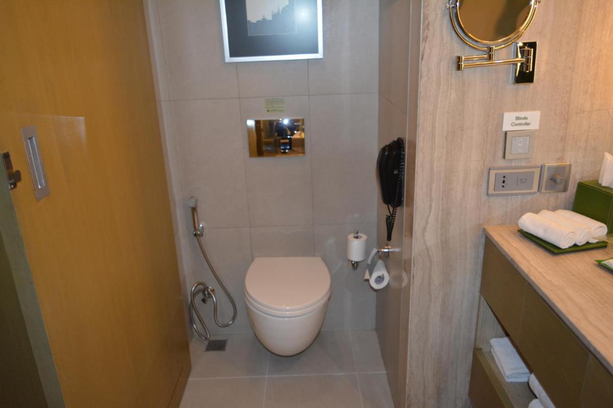 a bathroom with a toilet and a phone in it at Holiday Inn New Delhi Aerocity by IHG in New Delhi