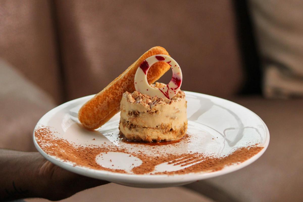 a piece of cake on a white plate with a pastry at Crowne Plaza Pune City Centre by IHG in Pune