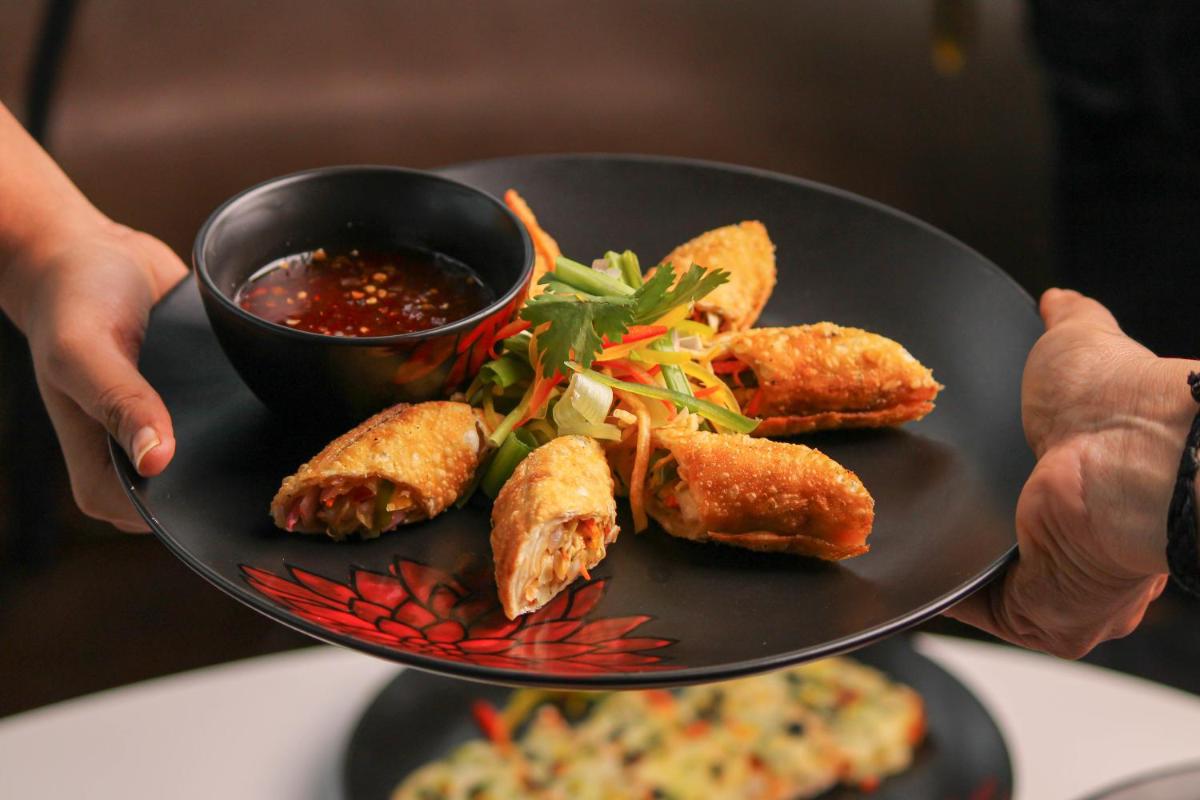 a person holding a plate with food on it at Crowne Plaza Pune City Centre by IHG in Pune
