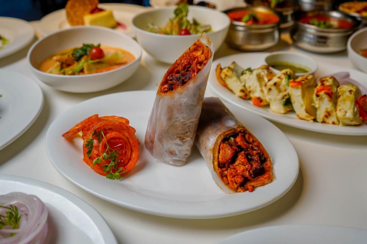 a table with plates of food and bowls of food at Crowne Plaza Pune City Centre by IHG in Pune