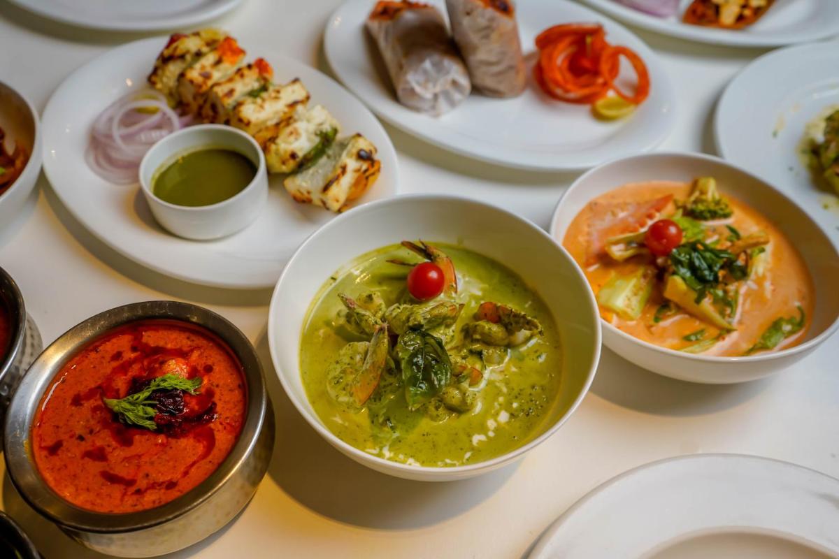 a table topped with bowls of soup and plates of food at Crowne Plaza Pune City Centre by IHG in Pune