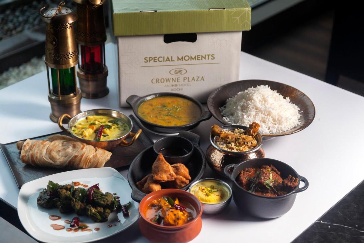 a table topped with different types of food and a box at Crowne Plaza Kochi by IHG in Cochin