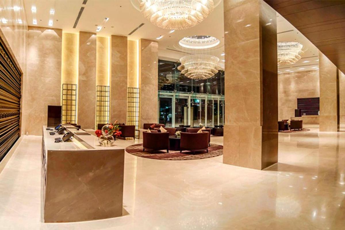 a lobby with couches and chairs in a building at Crowne Plaza Kochi by IHG in Cochin