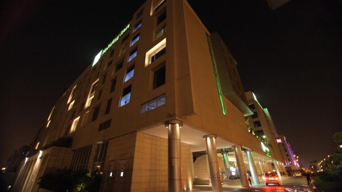 a tall building with lights on it at night at Holiday Inn New Delhi Aerocity by IHG in New Delhi