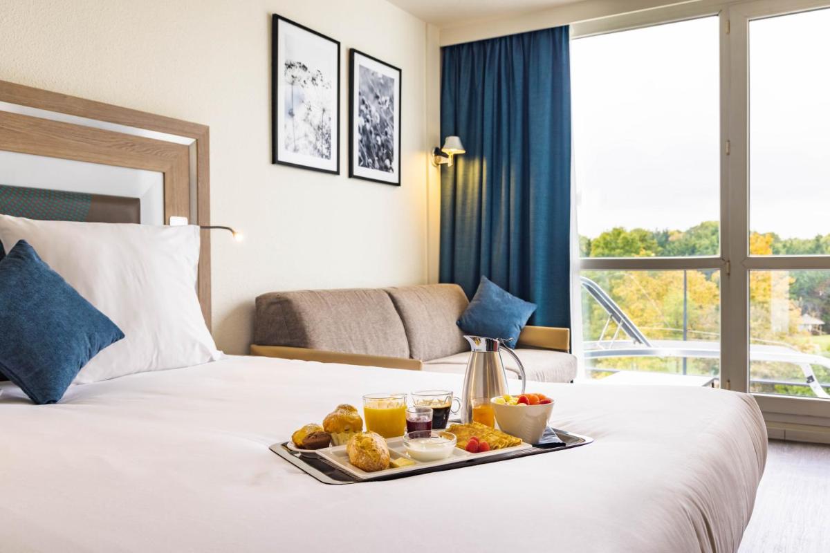 Un ou plusieurs lits dans un hébergement de l'établissement Novotel Senart Golf De Greenparc