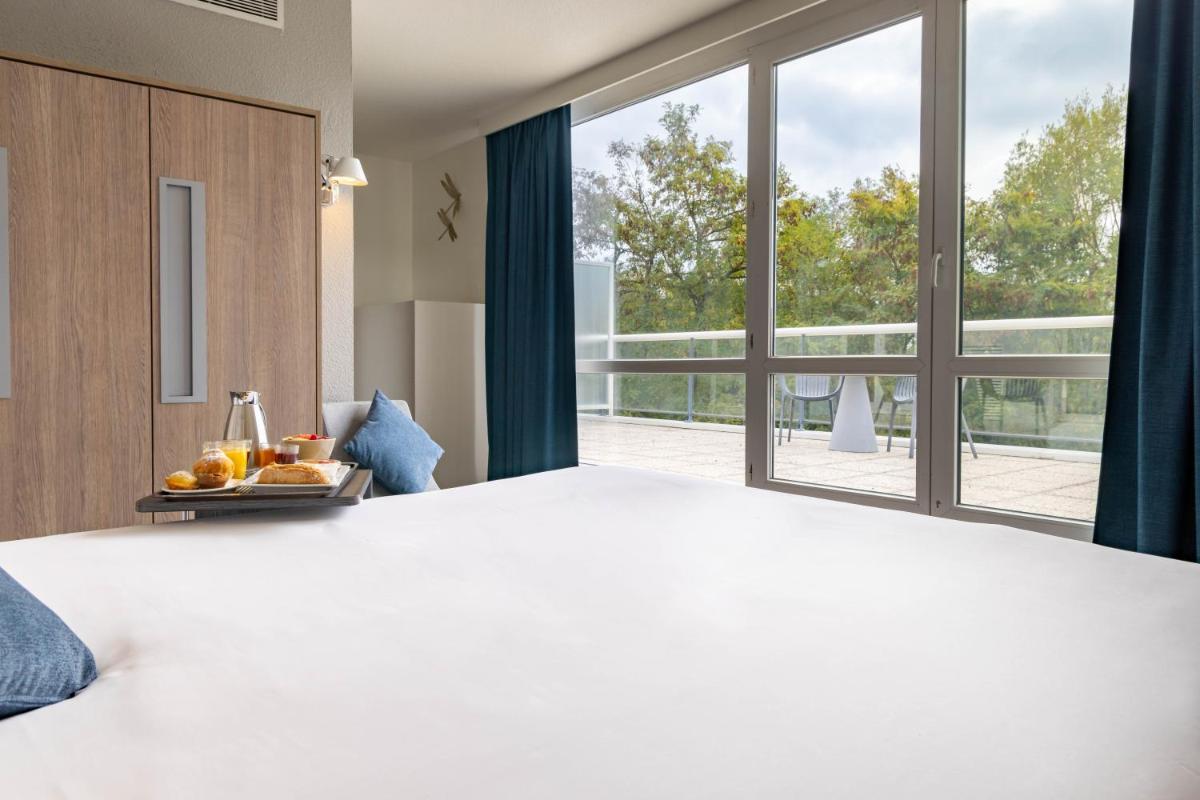 Un ou plusieurs lits dans un hébergement de l'établissement Novotel Senart Golf De Greenparc