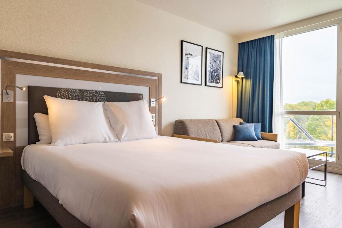 Un ou plusieurs lits dans un hébergement de l'établissement Novotel Senart Golf De Greenparc