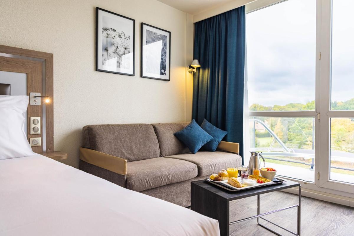 Un ou plusieurs lits dans un hébergement de l'établissement Novotel Senart Golf De Greenparc