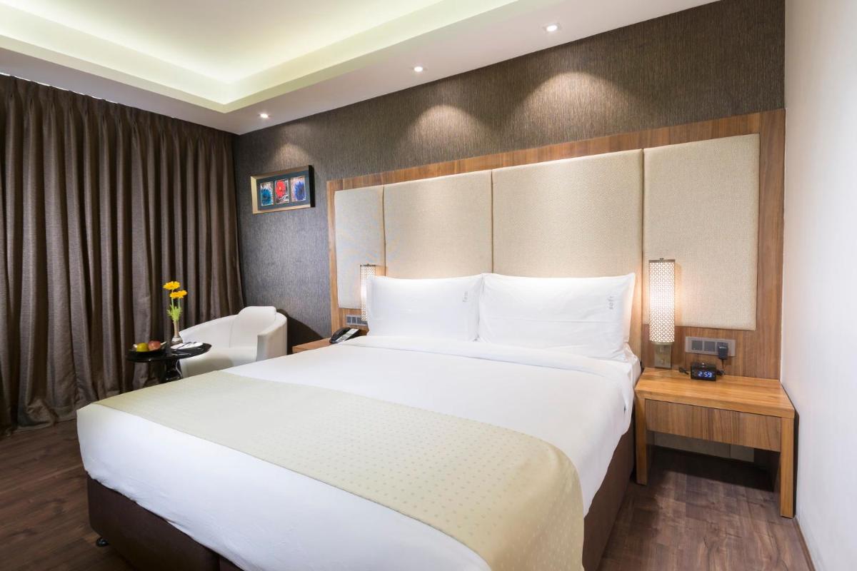 a hotel room with a large bed with white pillows at Holiday Inn Kolkata Airport by IHG in Kolkata