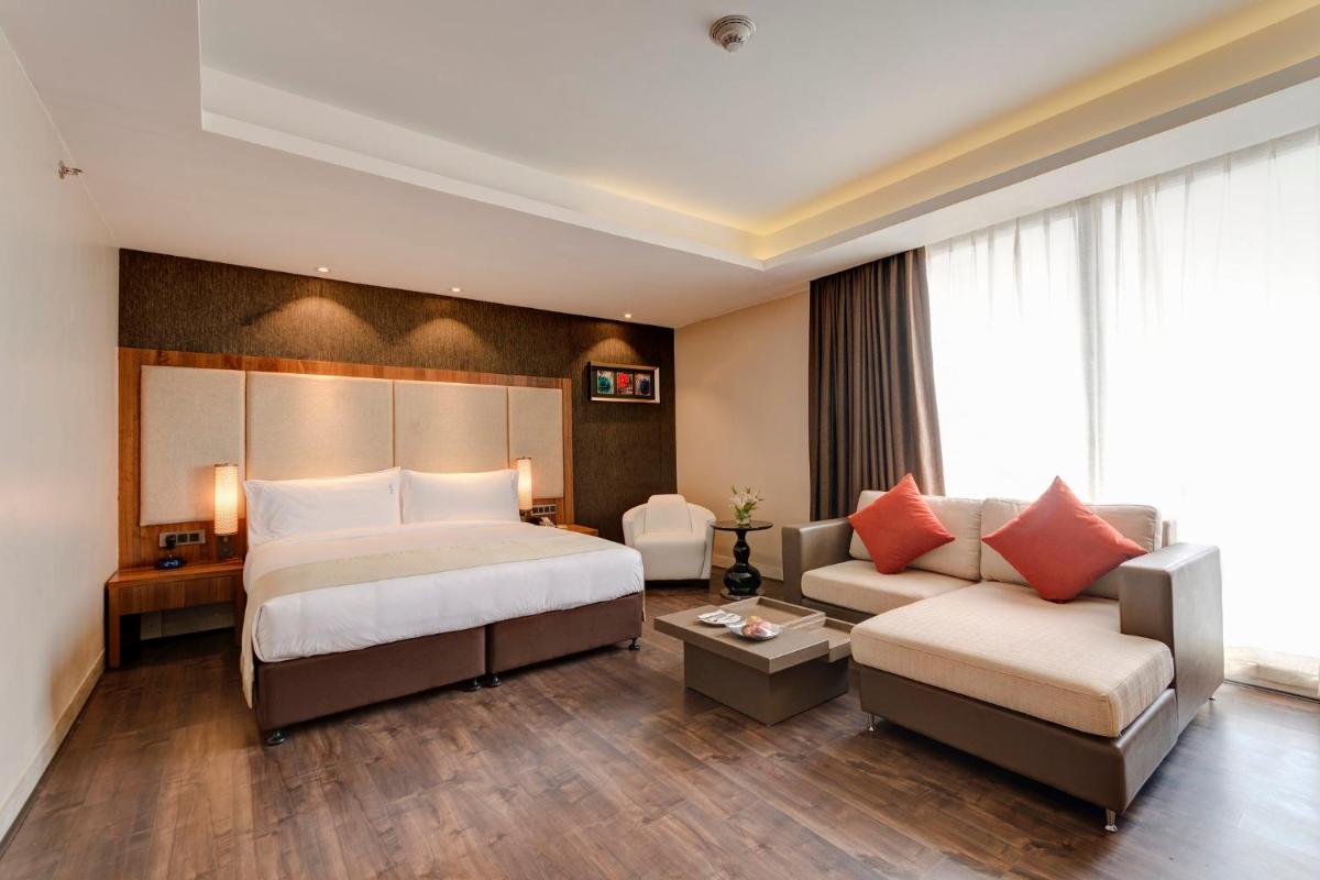 a hotel room with a bed and a couch at Holiday Inn Kolkata Airport by IHG in Kolkata