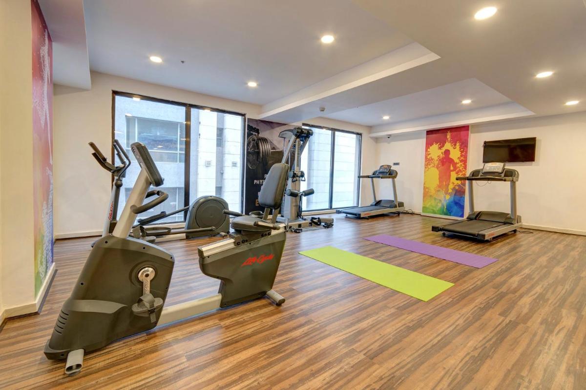 a gym with treadmills and ellipticals in a room at Holiday Inn Kolkata Airport by IHG in Kolkata a gym with treadmills and ellipticals in a room at Holiday Inn Kolkata Airport by IHG in Kolkata