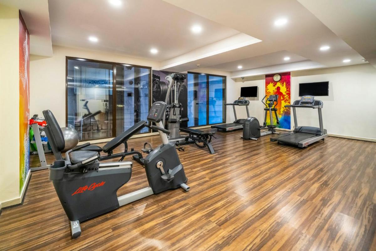 a gym with treadmills and elliptical machines at Holiday Inn Kolkata Airport by IHG in Kolkata