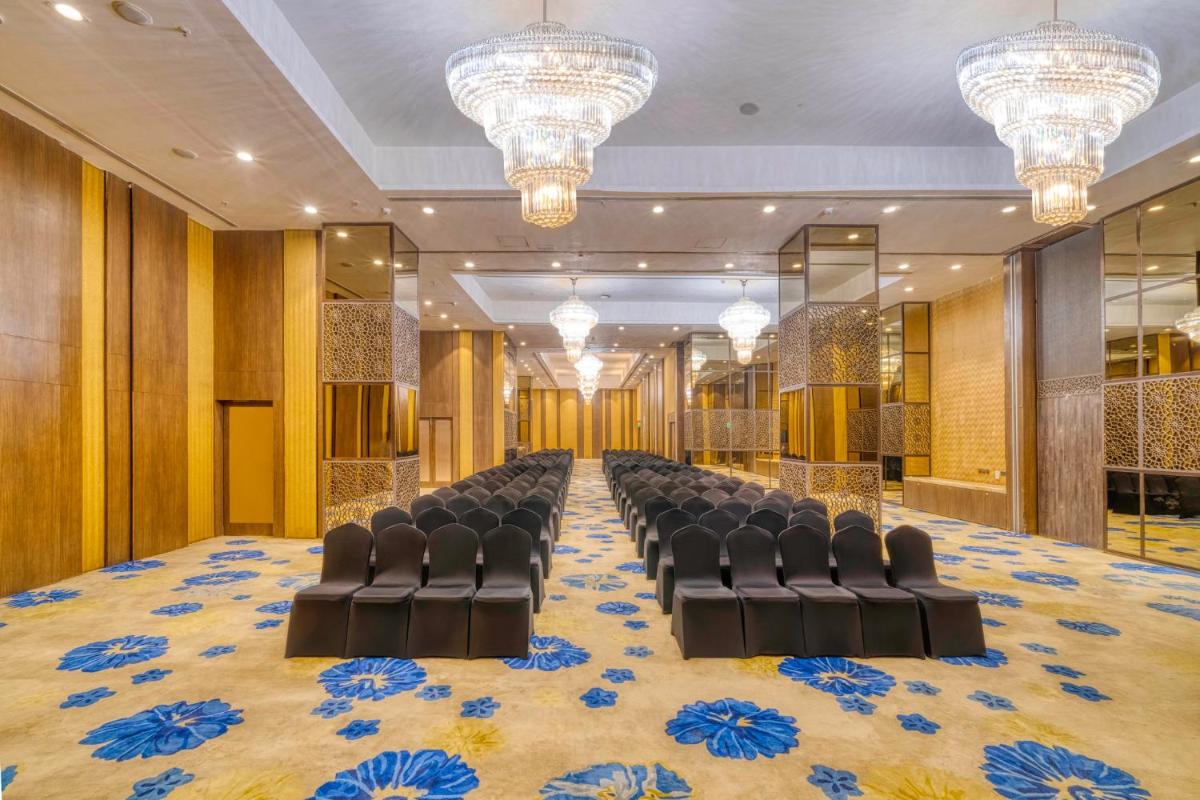 a conference room with a row of chairs and chandeliers at Holiday Inn Kolkata Airport by IHG in Kolkata