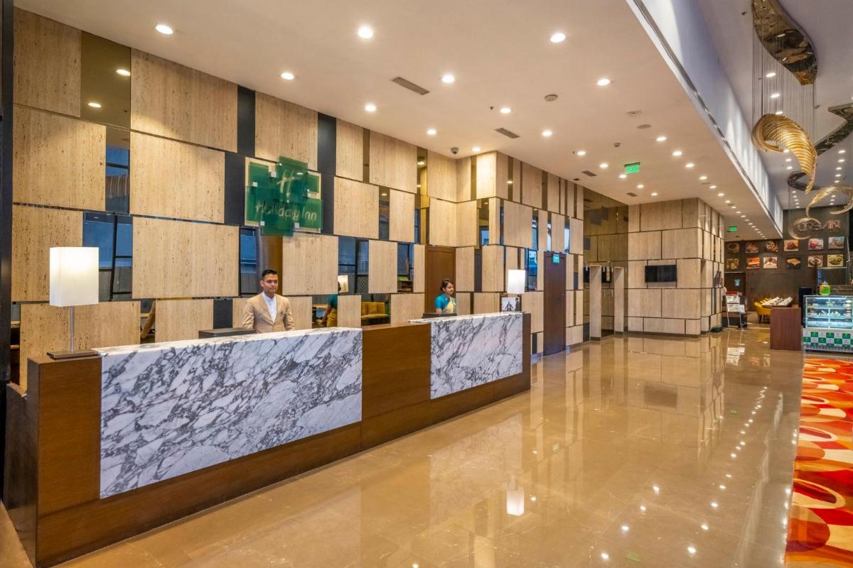 a lobby of a hotel with a reception desk at Holiday Inn Kolkata Airport by IHG in Kolkata