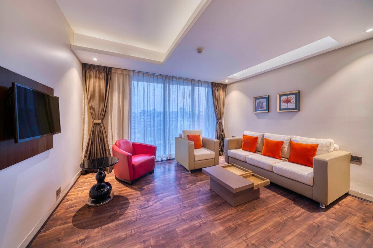 a living room with a couch and a tv at Holiday Inn Kolkata Airport by IHG in Kolkata