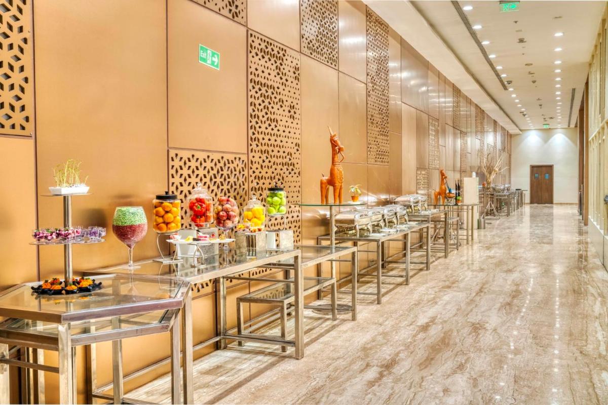 a row of tables with vases on them in a lobby at Holiday Inn Kolkata Airport by IHG in Kolkata