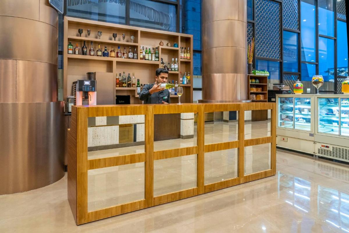 a man standing at a counter in a store at Holiday Inn Kolkata Airport by IHG in Kolkata