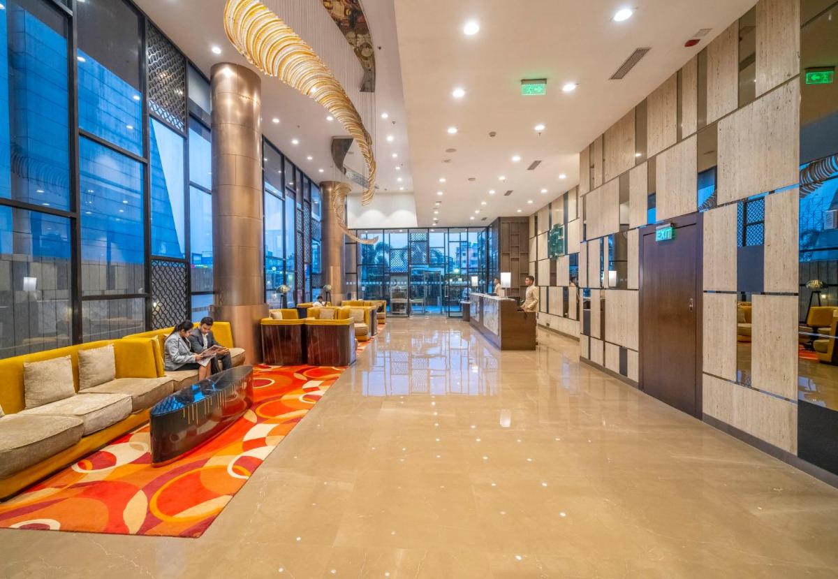 a lobby with couches and chairs in a building at Holiday Inn Kolkata Airport by IHG in Kolkata