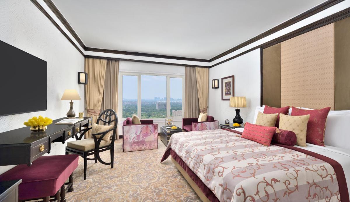 a hotel room with a large bed and a desk and a desk at Taj Mahal, New Delhi in New Delhi