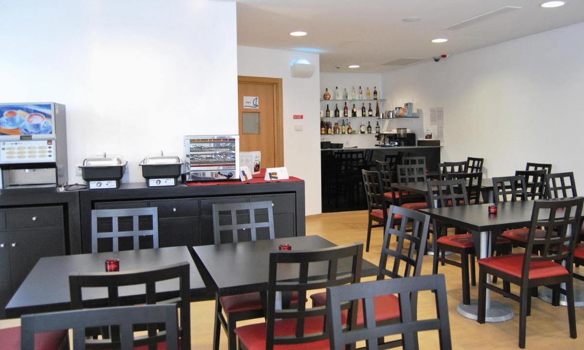 uma sala de jantar com mesas e cadeiras em um restaurante em Hotel Mira Sagres em Vila do Bispo