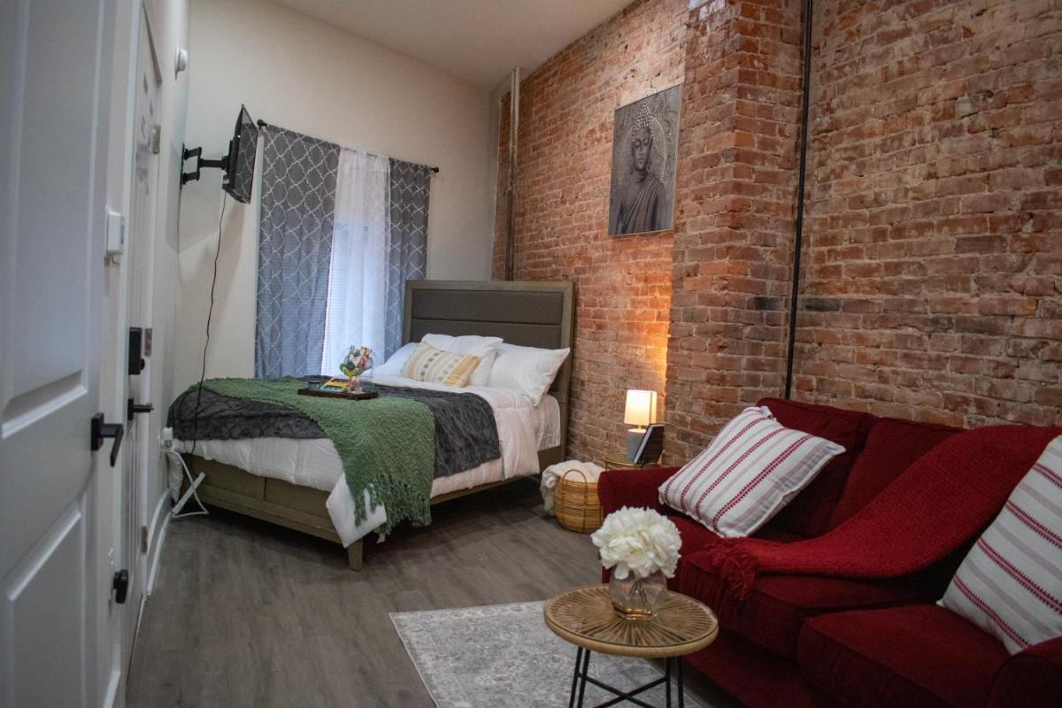 Idiosyncratic_ Brick wall style, studio apartment. - Housity