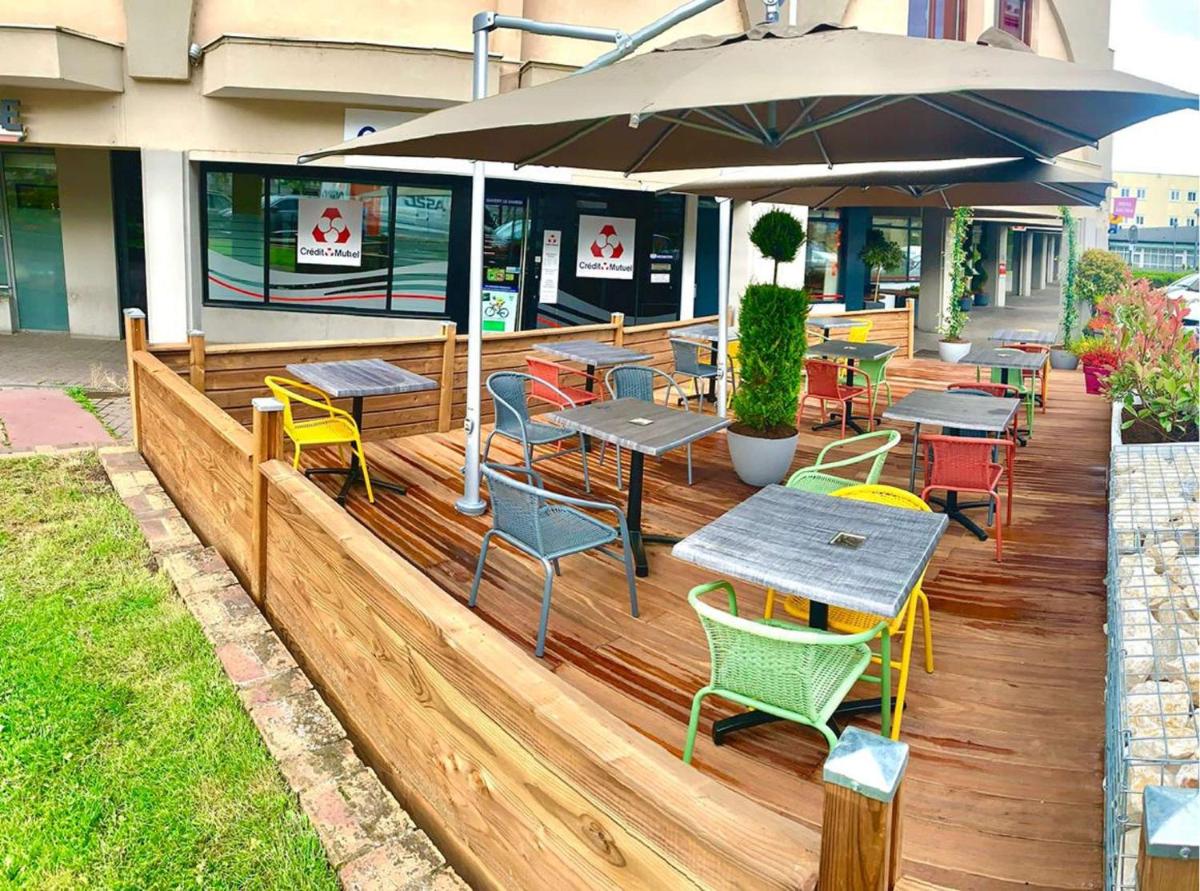 un restaurant avec des tables, des chaises et un parasol dans l'établissement Best Western Hotel & Spa Austria-La Terrasse, à Saint-Étienne