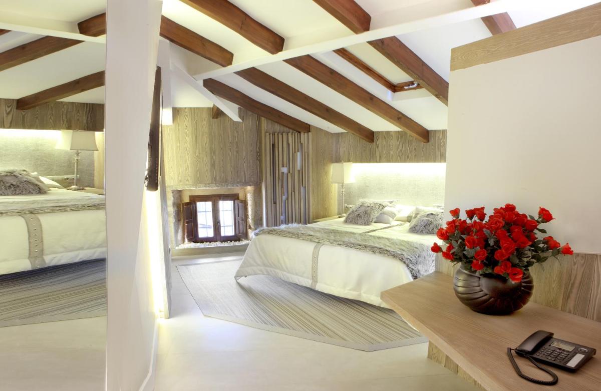 1 dormitorio con 2 camas y un jarrón de flores sobre una mesa en Hotel Las Treixas, en Puebla de Sanabria 44 fotos más