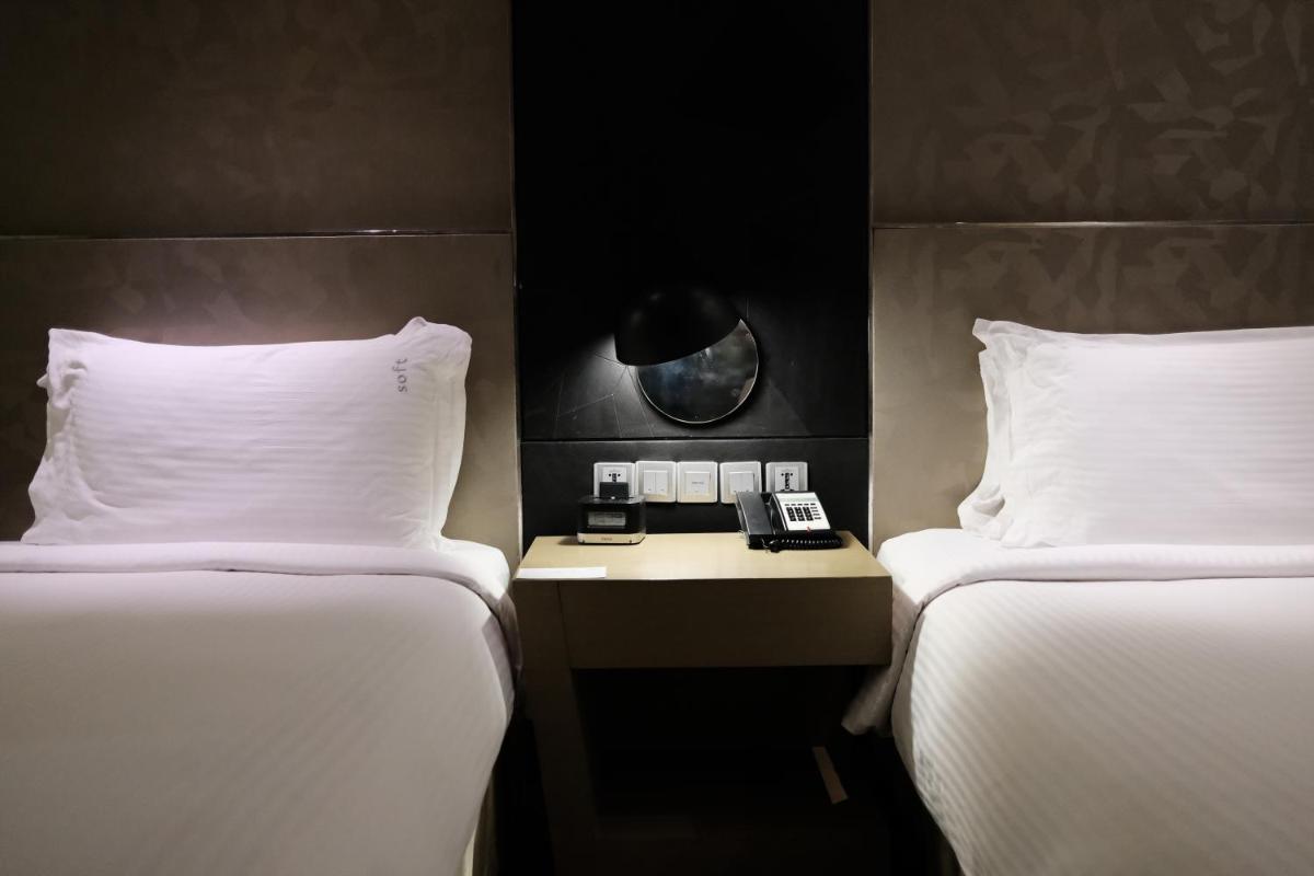 a hotel room with two beds and a phone on a table at Holiday Inn New Delhi Aerocity by IHG in New Delhi
