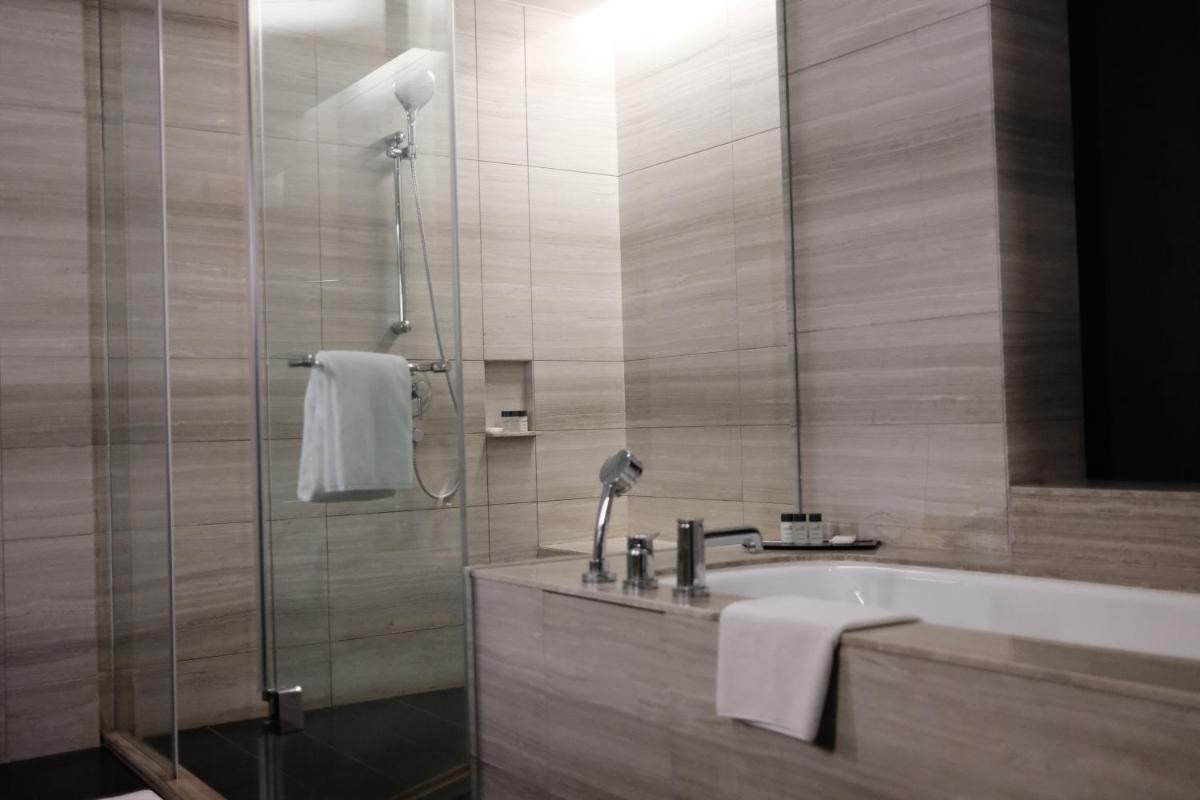 a bathroom with a shower and a tub and a sink at Holiday Inn New Delhi Aerocity by IHG in New Delhi