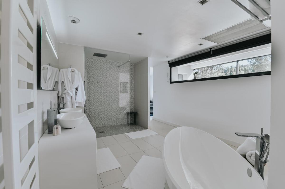 - une salle de bains blanche avec 2 toilettes et un lavabo dans l'établissement Le Meez, à Carcassonne