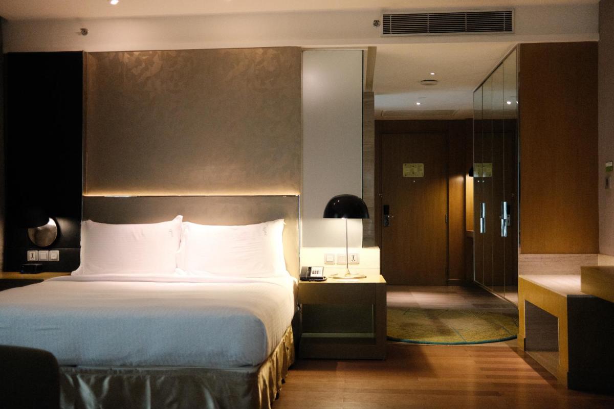 a hotel room with a bed and a desk with a lamp at Holiday Inn New Delhi Aerocity by IHG in New Delhi