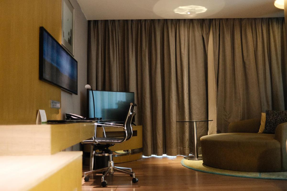 a hotel room with a desk and a chair and a television at Holiday Inn New Delhi Aerocity by IHG in New Delhi