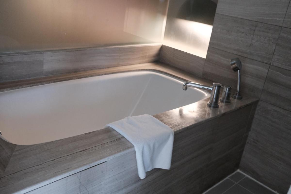 a bath tub with a faucet and a sink at Holiday Inn New Delhi Aerocity by IHG in New Delhi