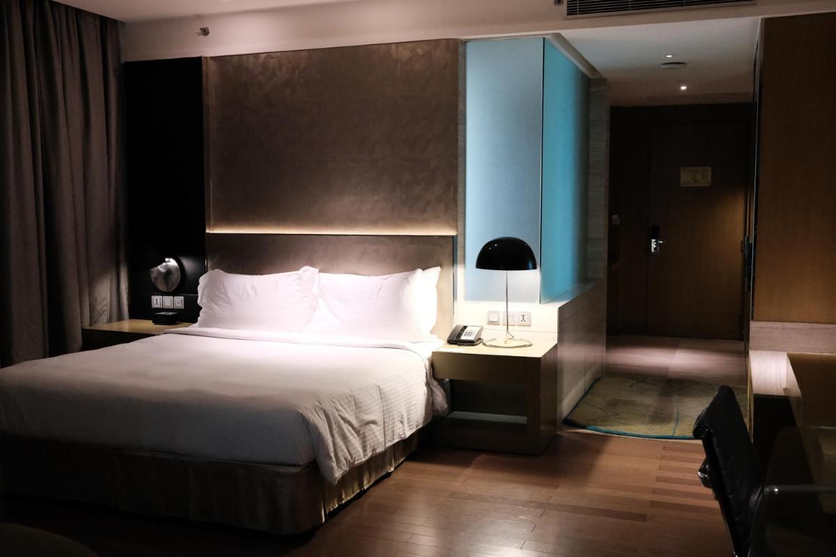 a hotel room with a bed and a desk with a lamp at Holiday Inn New Delhi Aerocity by IHG in New Delhi