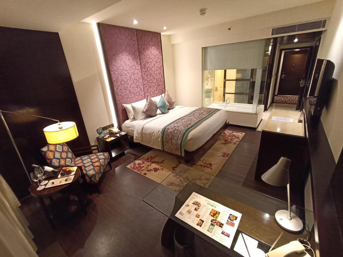 a hotel room with a bed and a table at Hotel Royal Orchid Jaipur, Tonk Road in Jaipur