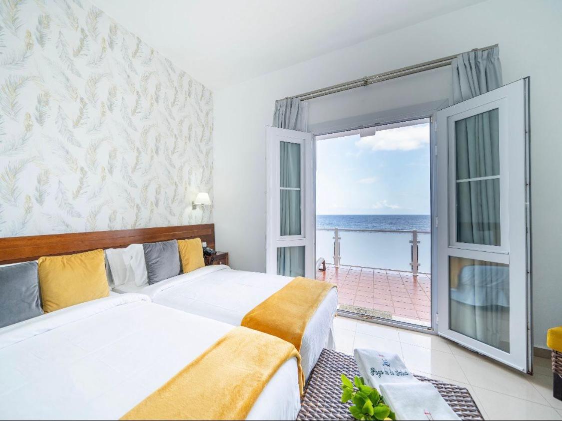 Un dormitorio con una cama y vista al mar. en Balneario Pozo de la Salud, en Sabinosa