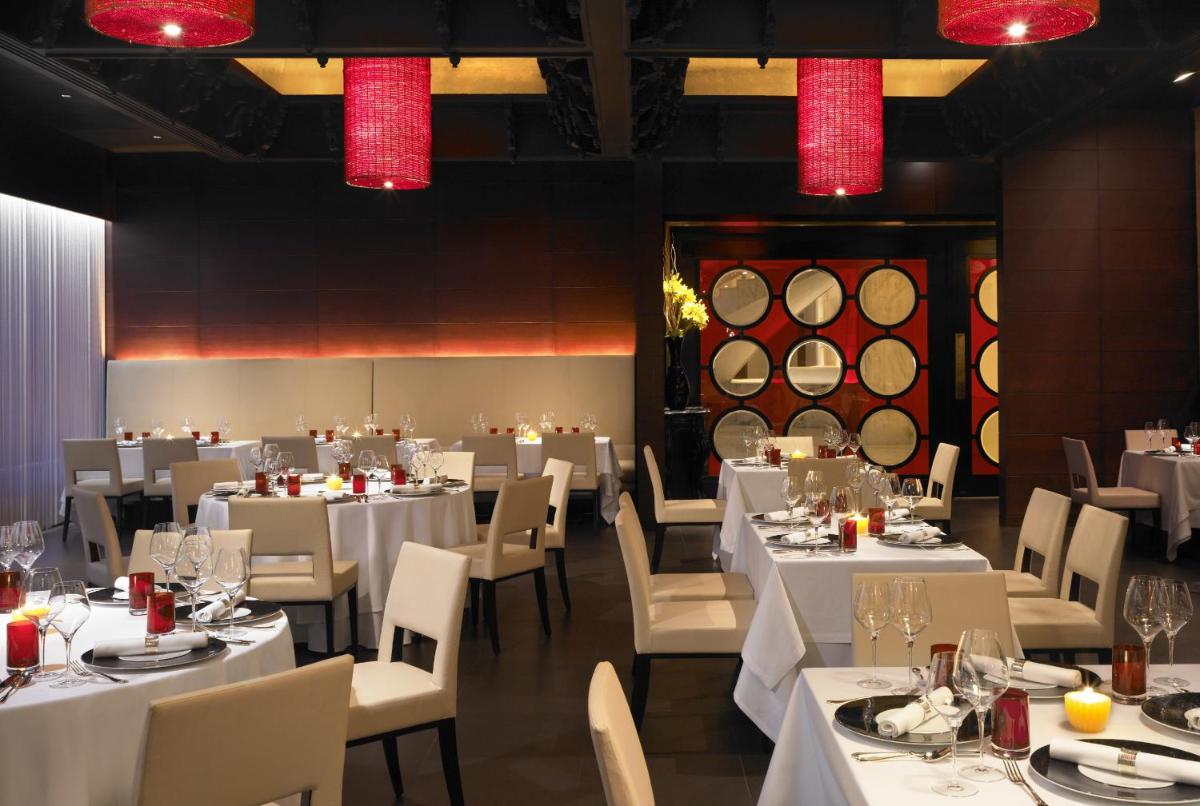 a restaurant with white tables and chairs and red lights at Taj Mahal, New Delhi in New Delhi