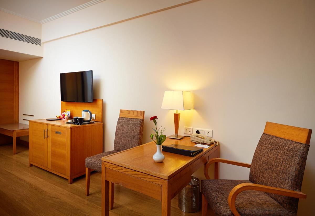 a room with a desk and two chairs and a table at Park Plaza Chennai OMR in Chennai