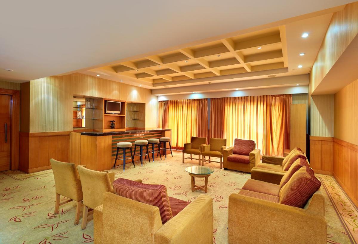 a living room with a couch and chairs and a bar at Park Plaza Chennai OMR in Chennai