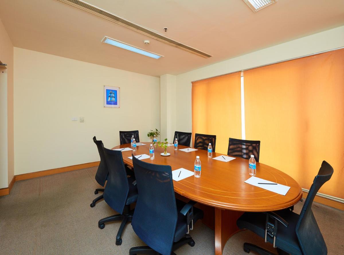 a conference room with a wooden table and chairs at Park Plaza Chennai OMR in Chennai