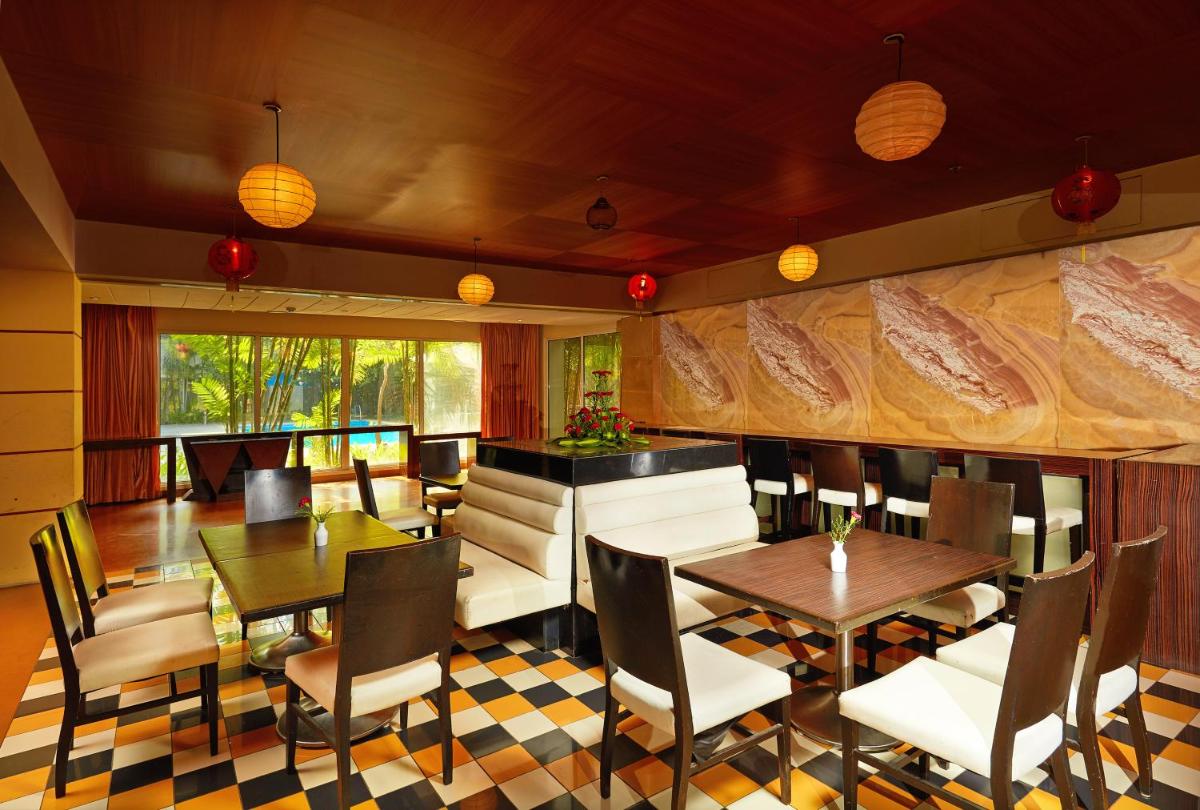 a restaurant with tables and chairs and a wall with a map at Park Plaza Chennai OMR in Chennai