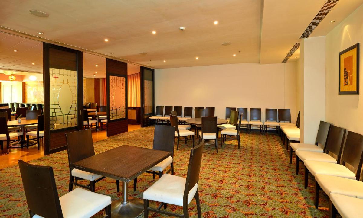 a waiting room with tables and chairs and a cafeteria at Park Plaza Chennai OMR in Chennai
