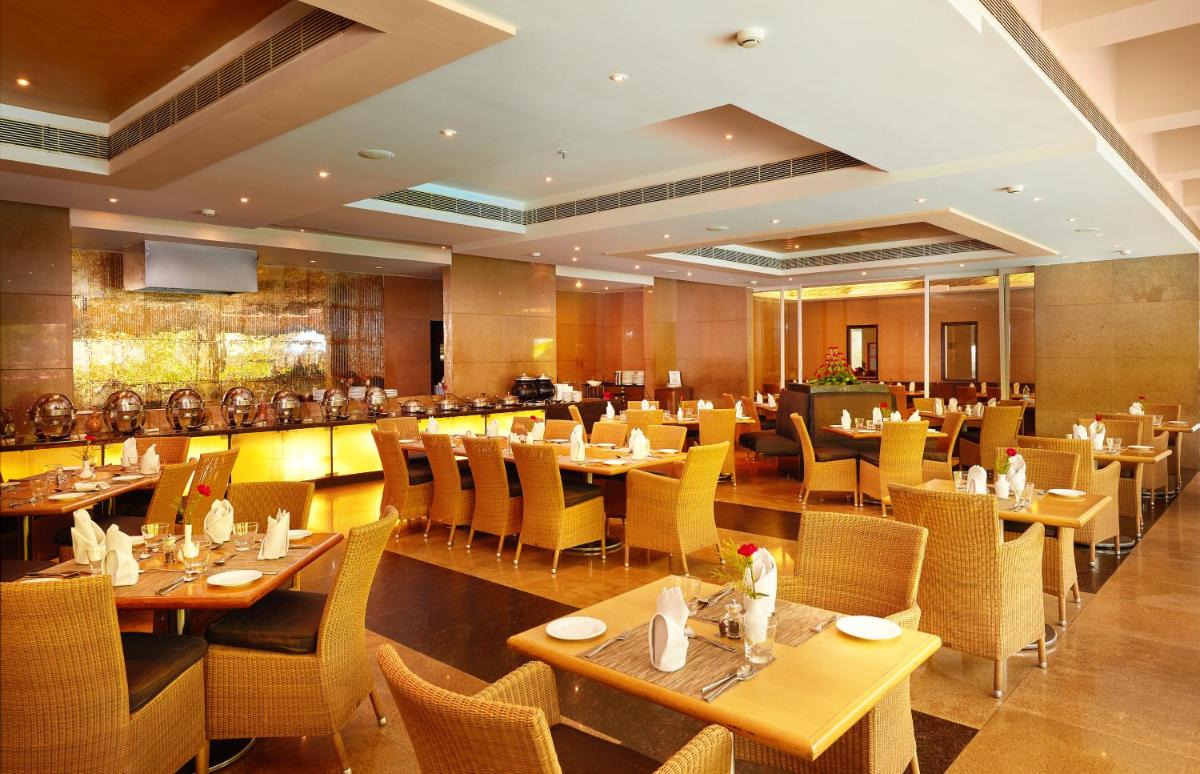 a dining room with tables and chairs in a restaurant at Park Plaza Chennai OMR in Chennai